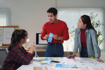 asian businessman presenting a mobile application screen mockup prototype to a team in a modern offi