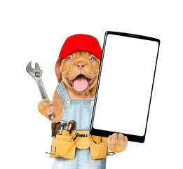 Poster - Funny Mastiff puppy wearing red cap and denim overalls with tool belt showing big smartphone with white blank screen in it paw. Isolated on white background
