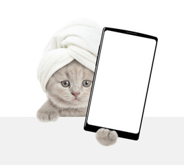 Leinwandbilder - Cute tiny kitten with towel on it head holds  big smartphone with white blank screen in it paw above blank white banner. isolated on white background