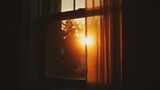 Bright sunlight streams through a window with a curtain