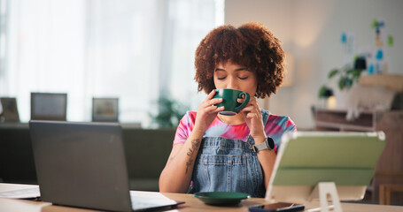 Poster - Coffee, laptop and tablet with designer woman in office of small business for break as creative. Computer, development and startup with freelance entrepreneur drinking caffeine beverage at work