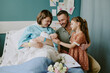 © AnnaStills - Happy family welcoming newborn baby in hospital room with mother, father, and daughter. Joyful moment captured as the sister gently touching siblings hand