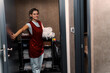 © DusanJelicic - Smiling chambermaid opening the hotel room door while carrying fresh towels, preparing to replace used ones and ensuring a comfortable stay for guests in the accommodation