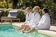 © Rido - Diverse women relaxing at poolside at spa center