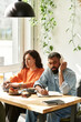 © LIGHTFIELD STUDIOS - Couple engages in productive remote work at a cozy cafe space together