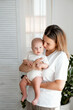 © Any Grant - mom and baby, a young beautiful mother with a little boy hugging at home in the bedroom, maternal care and love, portrait of a happy mother with a child, healthy motherhood.