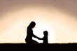 © Christin Lola - Mother Praying with her Young Child Outside at Sunset.