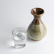 © Shousei - オフホワイトのマットな背景で、徳利とお猪口に注がれた日本酒が静かに飾られる