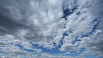 Wall Mural - Time lapse of white to gray clouds moving through a bright blue summer sky. Isolated to sky only.
