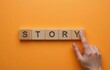 © nanang - Story symbol. Businessman Hand turns cubes with words Story. Beautiful orange background. Business and Story concept. Copy space