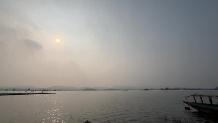 Sticker - The sun is setting over the lake.
