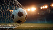 © MasTPX - A striking soccer ball les in the net after a goal du an intense night game at a brightly lit stadium, captu the thrill of the sport beautifully.