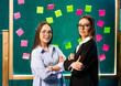 © Vadim - Women in creative collaboration. Two women confidently pose in a colorful workspace filled with sticky notes, highlighting teamwork and innovation.
