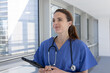 © ReeldealHD images - Smiling Female Doctor in Scrubs Holding Tablet