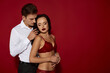 © LIGHTFIELD STUDIOS - Passionate embrace between a loving couple against a vibrant red backdrop creating alluring romance