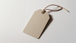 © Ali Khan - Elegant beige luggage tag featuring a brown string on a crisp white backdrop for sophisticated travel identity