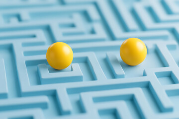 two yellow spheres navigate a blue maze, representing problem-solving and strategic thinking in a ch