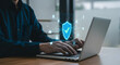 © Pixel Studio - Cyber security data protection privacy concept man using laptop with shield icon secure network
