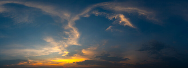 Wall Mural - cumulus sunset clouds with sun setting down on dark background.orange cloud sky and blue sky. beauti