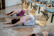 © Parichat - Women practicing child's pose during pilates class