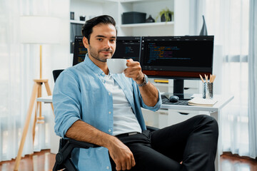 profile's smart it developer looking camera to pose holding coffee cup against on software developme