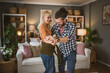 © Miljan Živković - One adult couple dance together and have fun at living room at home