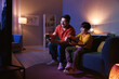 © New Africa - Happy father and his son playing video games on sofa in living room at night