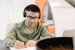 © Oleksii Syrotkin/Stocksy - Focused asian IT company employee writing in copybook