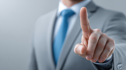 A man in a suit is pointing at a button on a screen