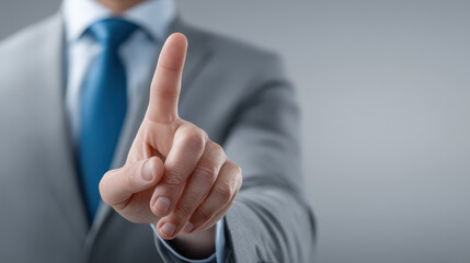 A man in a suit is pointing at a button on a screen