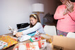 © Alvaro Lavin/Stocksy - Happy girl opening christmas presents while her mother is clapping