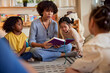 © Jovo Jovanovic/Stocksy - Teacher reading storybook for children in daycare