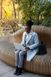 © Oleksii Syrotkin/Stocksy - Female copywriter working remotely while sitting on bench in park