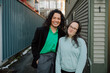 © Rob and Julia Campbell/Stocksy - Smiling Friends Sharing a Moment in an Urban Alleyway Setting
