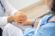 © Santi Nuñez/Stocksy - Doctor comforting senior patient by holding hands, providing care