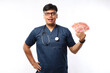 © ArvStd - Handsome happy asian male doctor smiles and holds fan of money banknotes indonesia rupiah
