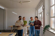 © BONNINSTUDIO/Stocksy - Diverse startup team walking and talking in modern office
