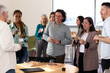 © VICTOR TORRES/Stocksy - Diverse group enjoying casual office gathering with snacks