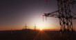 © Bernt Moss/Stocksy - Huge power lines close up with a sunset landscape