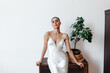 © Viktor Solomin/Stocksy - Elegant woman in a satin dress posing confidently