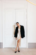 © Viktor Solomin/Stocksy - Fashionable model poses elegantly in a chic outfit in a bright room