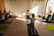 © Alvaro Lavin/Stocksy - Group of people practicing yoga in a studio with instructor