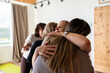 © Alvaro Lavin/Stocksy - Women are hugging during group therapy session