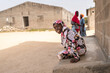 © Alvaro Lavin/Stocksy - Young senegalese girl sitting and smiling in a village in Africa