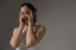 © Danil Nevsky/Stocksy - Young woman covering face with hands expressing anxiety and stress