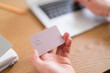 © Studio Marmellata - A person holds a credit card while using a laptop. They are possibly making an online purchase or managing their finances.