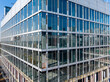 © ma yic/Stocksy - Construction Workers Installing Glass Windows on a Building