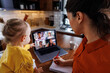 © Jovo Jovanovic/Stocksy - A Working mother with daughter during video conference