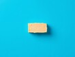 © Watcharaphonsak - an image of a piece of cheese on a blue surface, there is a piece of cheese on a blue surface