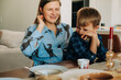 © Olga Moreira/Stocksy - Mom and son share a playful moment at breakfast